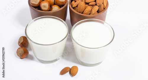 Glass of hazelnut milk and almond isolated on white background.