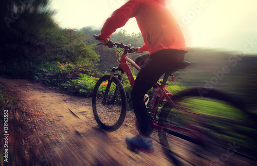 riding mountain bike on sunrise forest trial
