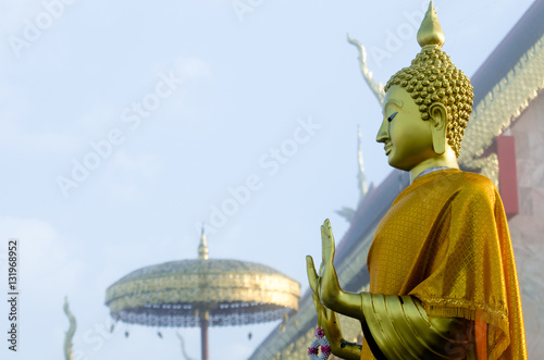 Attitude of the Buddha // Buddha image standing beside the  Buddha image hall at Wat Phra That Jom Jor photo