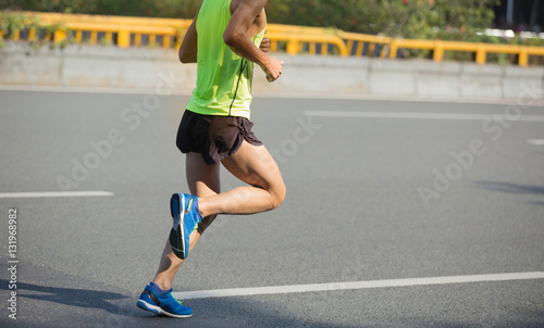 fitness male marathon runner running on city road