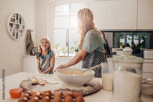 Mother and happy daughter in kitchen