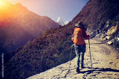 young woman backpacker trekking at the himalaya mountains