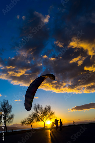 Silhouette skydiver parachutist training at sunset