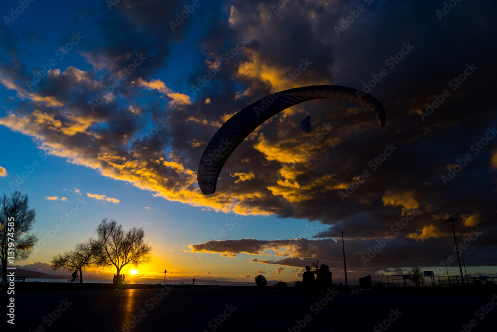 Silhouette skydiver parachutist training at sunset