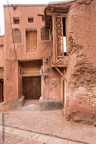 The tipical red mud-brick houses in the ancient village of Abyan, in Iran photo