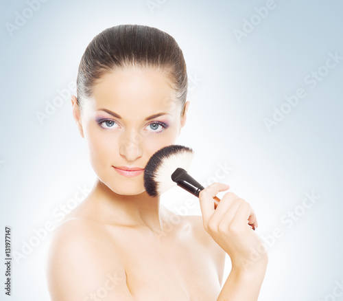 Portrait of a woman holding a makeup brush