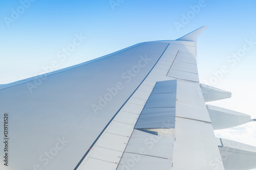 Airplane wing open speed break or spoiler seen through window