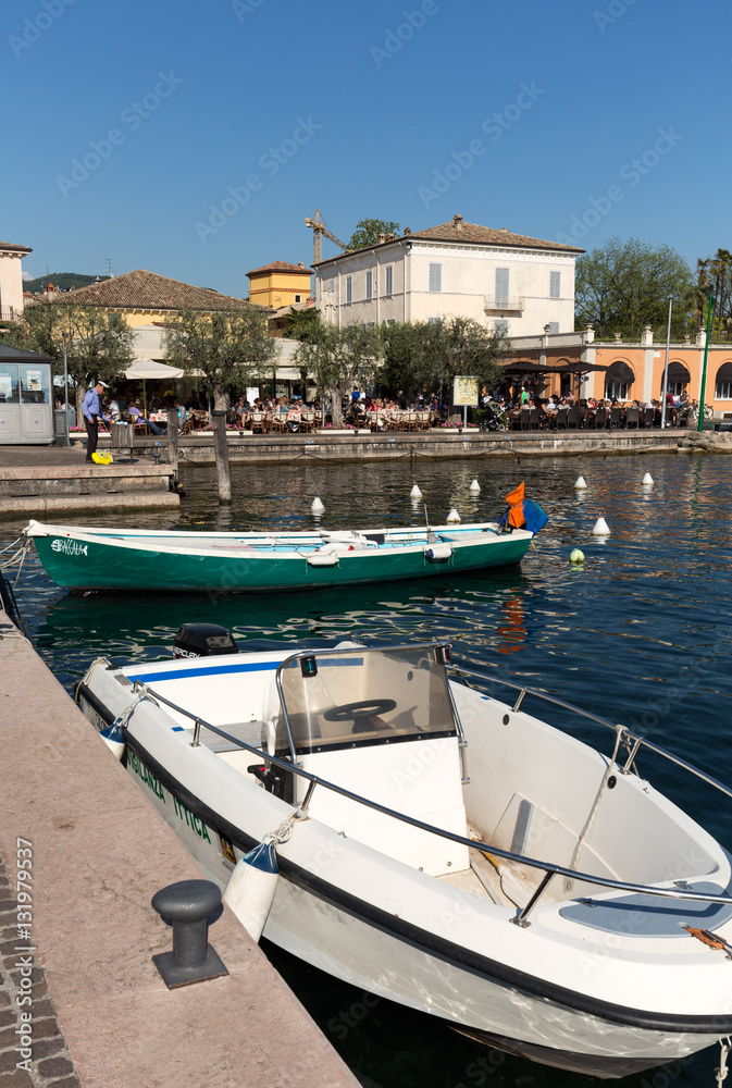 Sailboats and fishing boats at Porto di Bardolino harbor on The Garda Lake . Italy