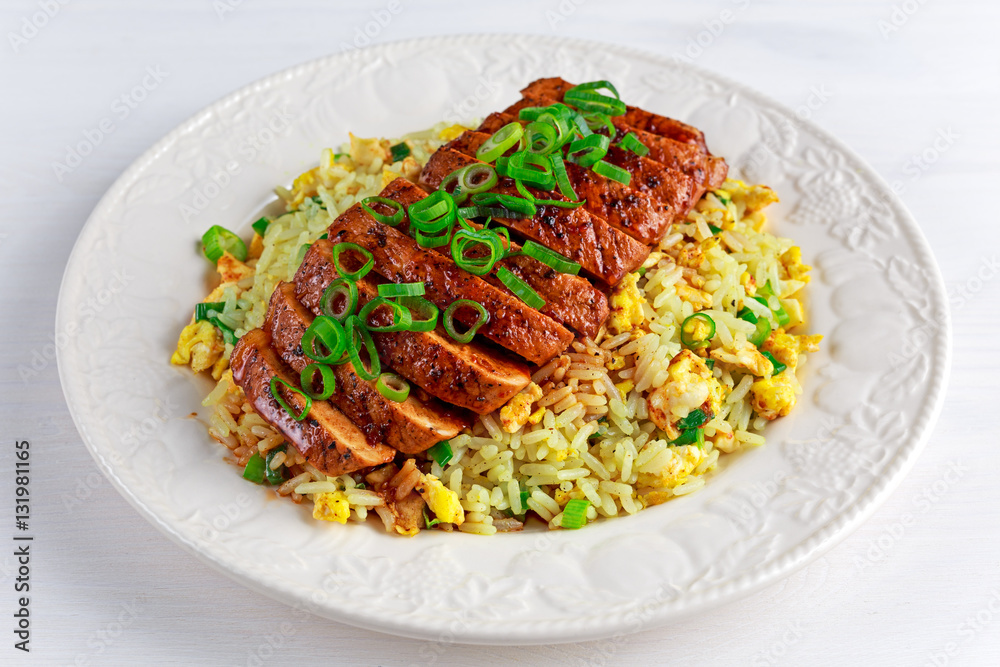 Chinese style Egg fried rice with sliced pork fillet on white wooden table. Chinese style Egg fried rice with sliced pork fillet on white wooden table.