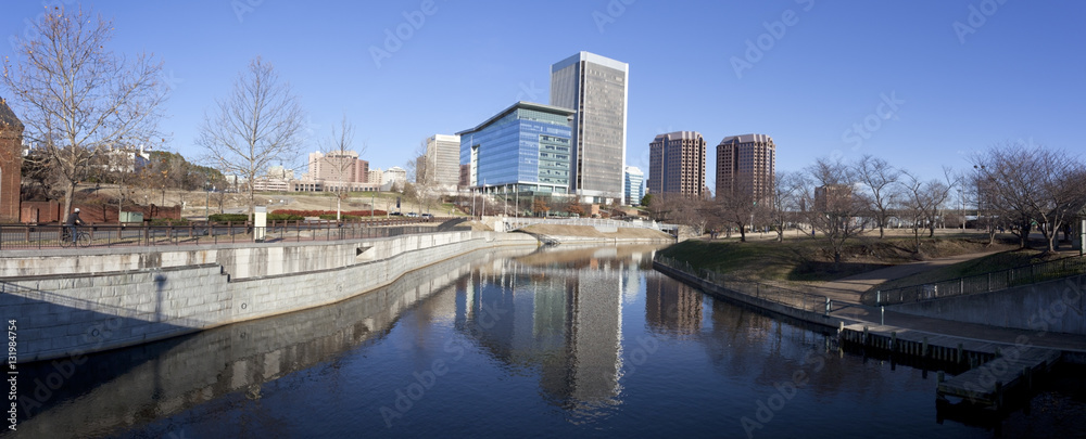 Late winter afternoon panorama in Richmond, Virginia looking north from under the Manchester Floodwall Walk with the T. Tyler Potterfield pedestrian bridge spanning the James River to the left. 