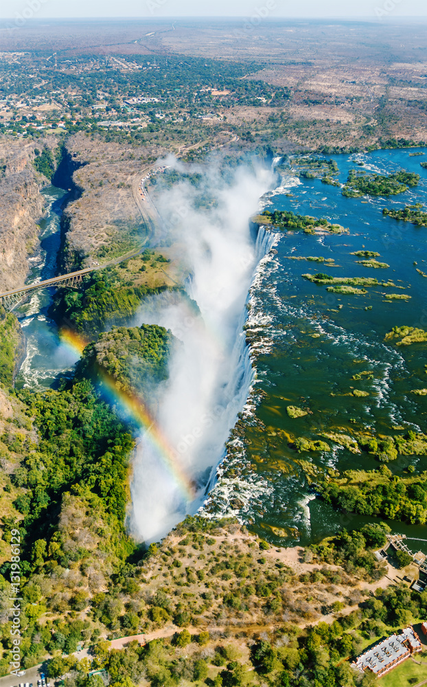 Fototapeta premium The Victoria falls is the largest curtain of water in the world (1708 m wide). The falls and the surrounding area is the National Parks and World Heritage Site (helicopter view) - Zambia, Zimbabwe