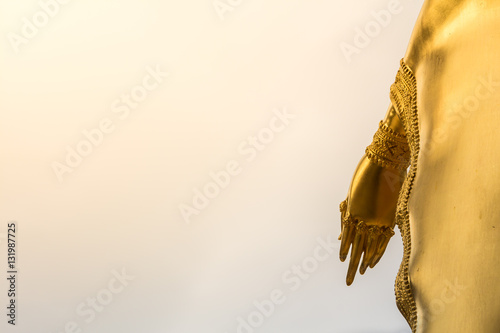 Hand of golden Buddha statue on blue sky background in Thailand