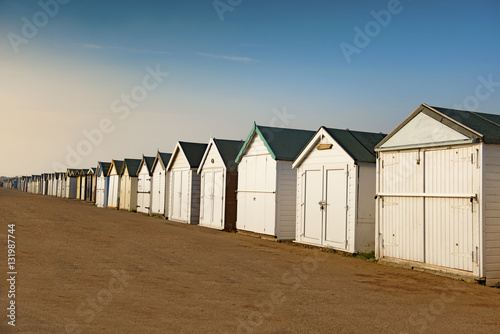 Fototapeta Naklejka Na Ścianę i Meble -  Beach huts in Shoeburyness, Essex. Photograph taken during the golden hour. The huts are closed and locked up as it is out of holiday season