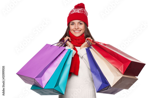 Surprised happy beautiful woman holding shopping bags in excitement. Christmas girl on winter sale, isolated on white background