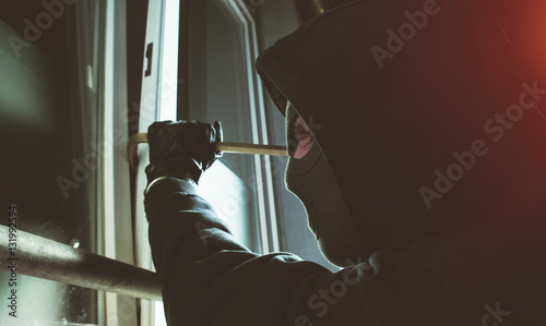Foto Einbrecher knackt fenster mit brecheisen