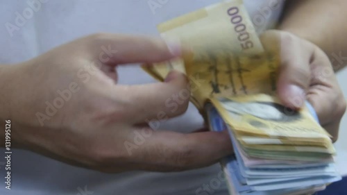 Man counting korean money in hands photo
