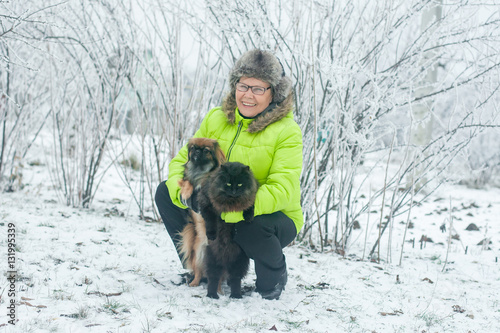 Woman with dog Pekingese and cat in winter park