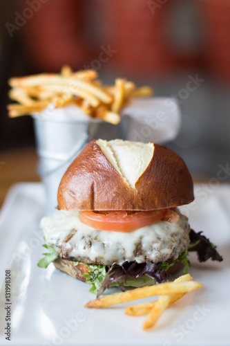 Cheeseburger on Pretzel Roll on White Plate photo