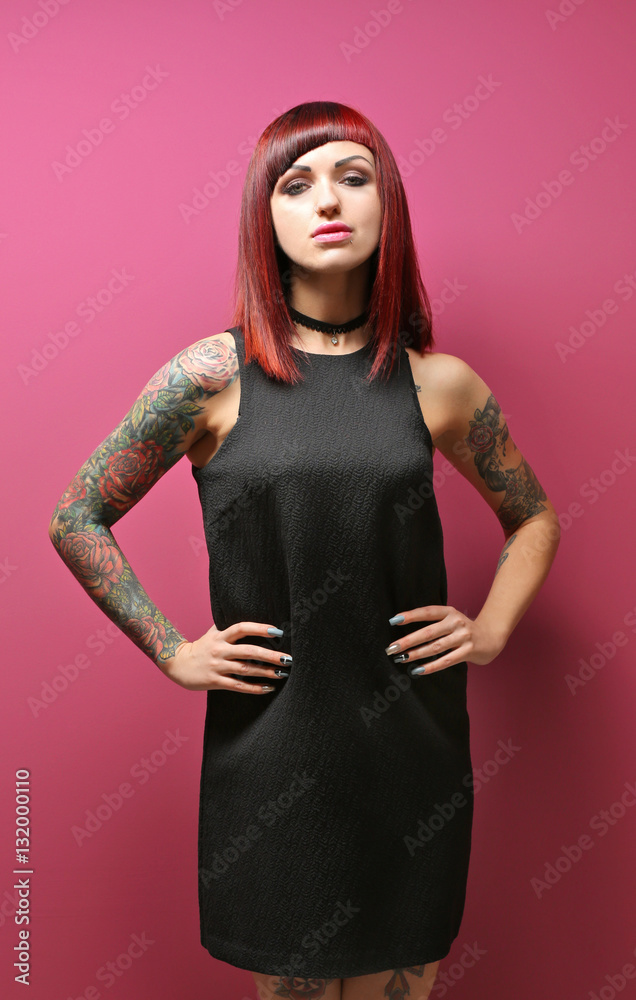 Beautiful girl with tattoo on color background