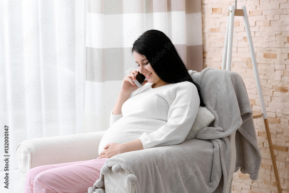 Beautiful young pregnant woman speaking by cellphone at home Beautiful young pregnant woman speaking by cellphone at home