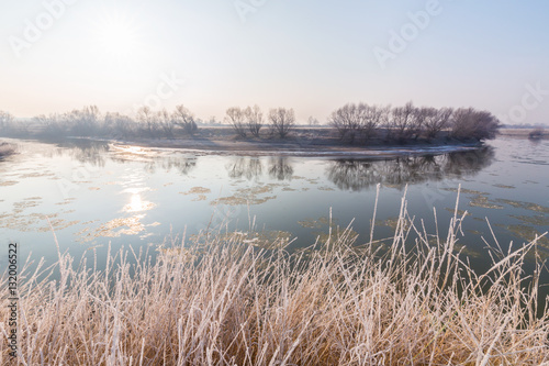 Fototapeta Naklejka Na Ścianę i Meble -  Winter scenery, with frozen river and frost cover vegetation on a cold, sunny, day