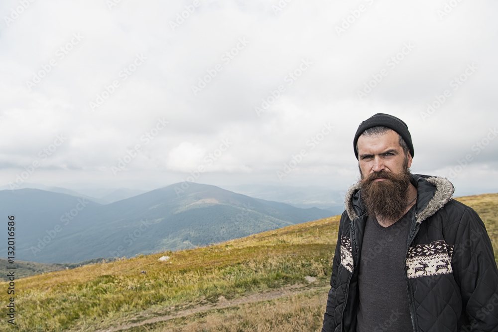 man hipster traveler with beard and moustache portrait on mountain