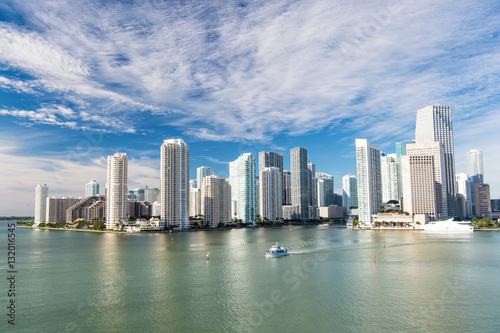 Aerial view of Miami skyscrapers with blue cloudy sky, boat sail © be free