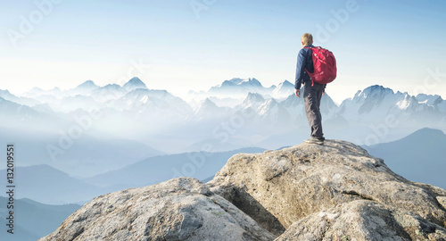 Tourist on the peak of high rocks. Sport and active life concept..