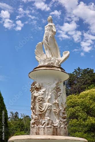 Summer architectural fountain with fresh cold water and kids under blue cloudy sky surrounded by green trees. Dendrarium park, Sochi, Russia, 3 Aug, 2016.  photo