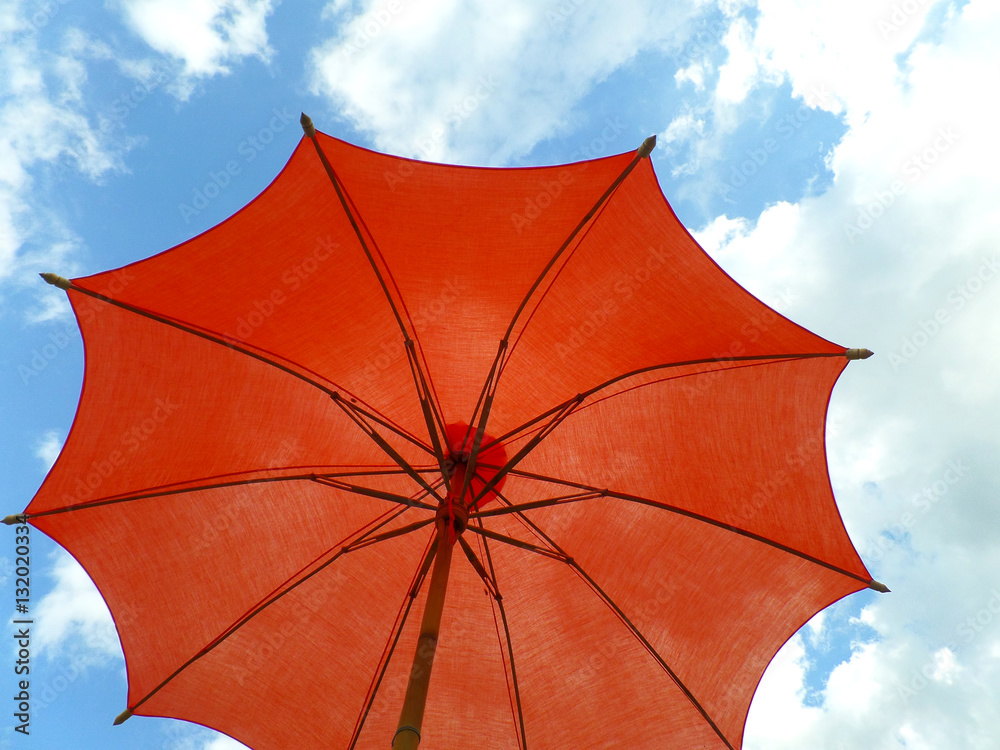 One red colored parasol against vivid blue sky and white cloud Stock Photo  | Adobe Stock