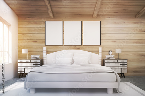 Double bed in a wooden room with posters, toned
