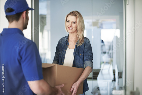 Woman getting a parcel from delivery man photo