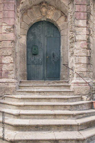 stone stairs leading to closed medieval door