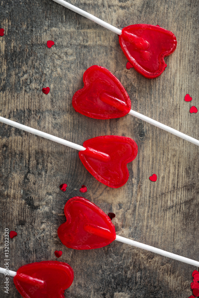 Red lollipops with heart shape on wooden background. Love concept. Valentine's Day.
Red lollipops with heart shape on wooden background. Love concept. Valentine's Day.
