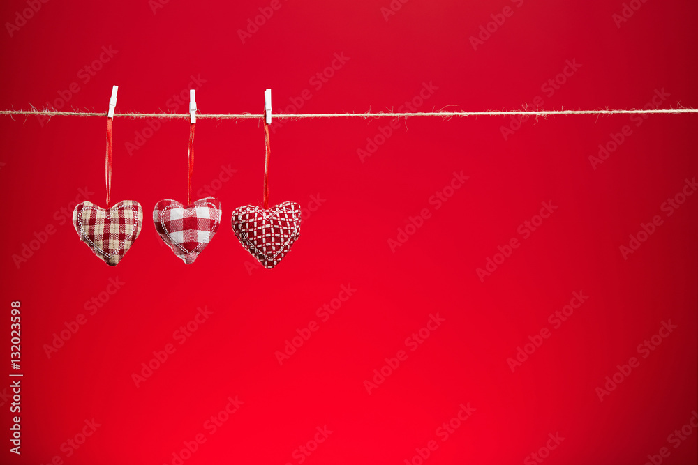 Three plush hearts on a red background