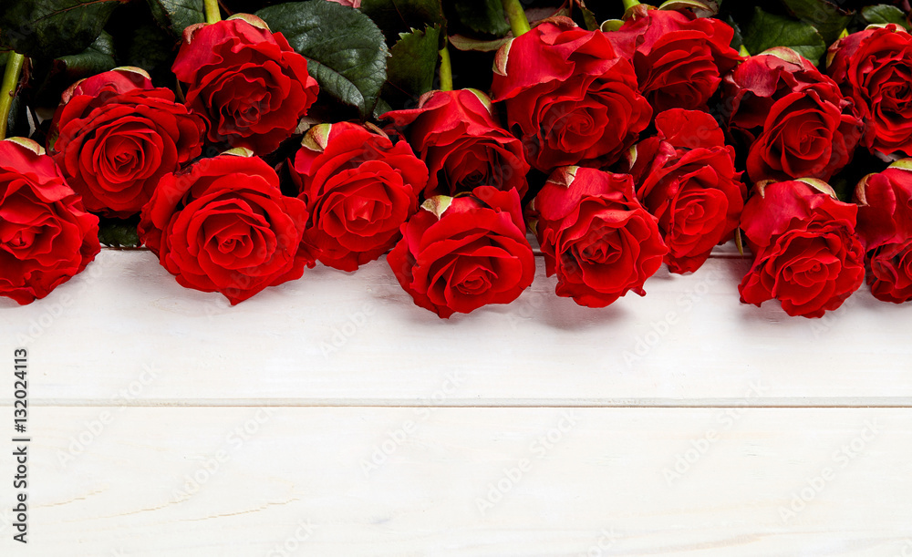 Buds of red roses on white wooden background Buds of red roses on white wooden background