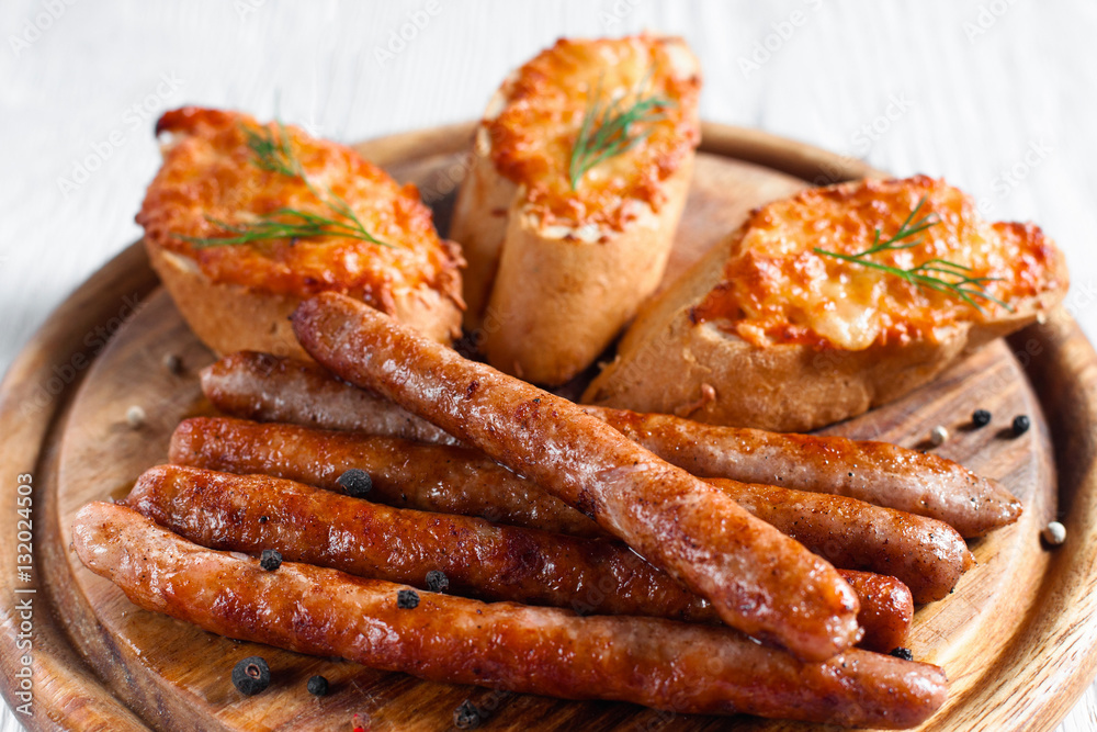 Catering platter with grilled sausages and canapes. Set of roasted fat snacks for beer on wooden board. Junk food, dieting, restaurant menu concept Catering platter with grilled sausages and canapes. Set of roasted fat snacks for beer on wooden board. Junk food, dieting, restaurant menu concept