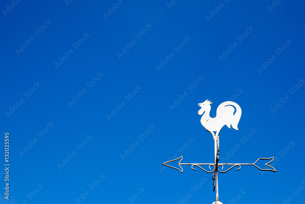 White rooster weather vane show the wind direction on blue sky b White rooster weather vane show the wind direction on blue sky b