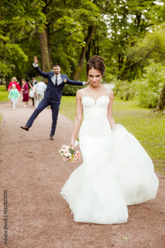 Young wedding couple walking together at park.