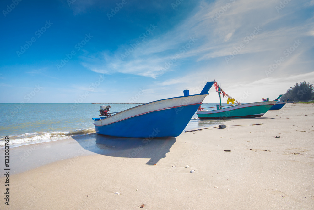 fishing boat on the beach with blue sky background in Thailand