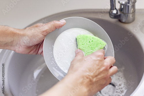 Fotografie young man washing dishes