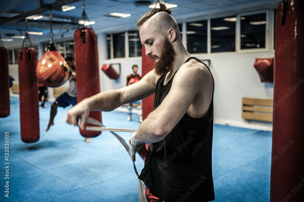 Fighter preparing for training, wrapping hands with boxing wraps