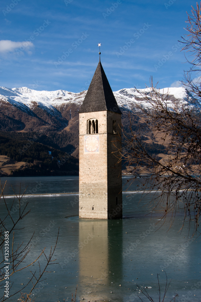 Sunken church tower at frozen lake resia, Italy