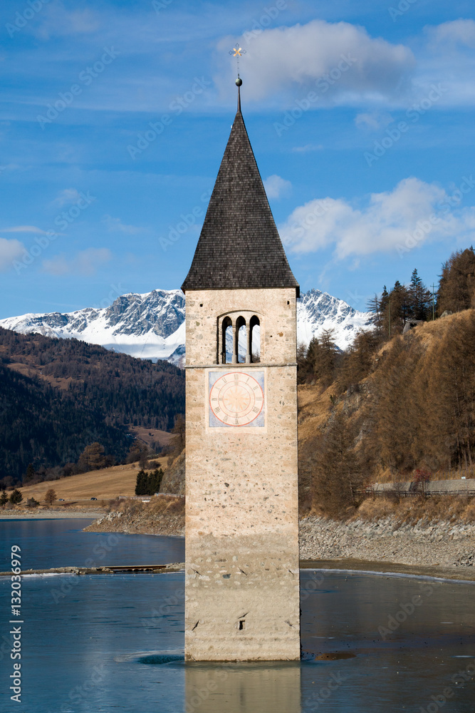 Tower of sunken church in frozen Lake Resia, Italy