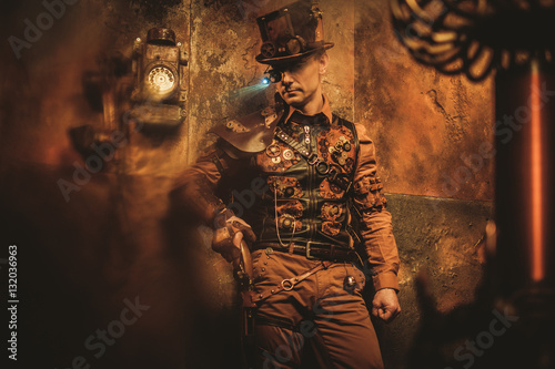 Portrait of steampunk man with various mechanical devices on vintage steampunk background