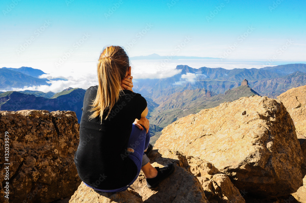 Mujer joven contemplando el Teide desde el Roque Nublo. Gran Canaria, España