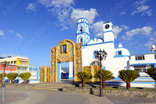 Colorful Church with blue sky background located near borders of Veracruz and Puebla, close to Pico de Orizaba, Iztaccihuatland Popocatepetl volcanoes, Mexico photo