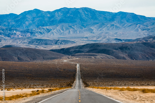 Road in the Death Valley National Park with mountains on the horizon. USA photo