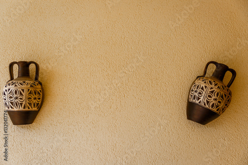 Two amphoras decorating the wall of a patio photo