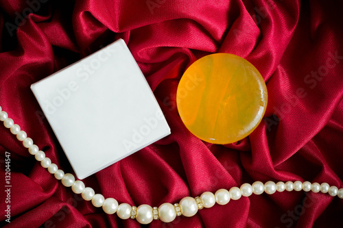 soap and box on red fabric background